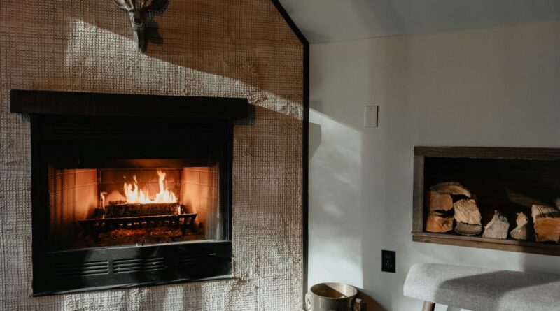 Moderner Wandkamin mit Holzlager: Stilvoller Kamin mit sauberer Glasscheibe, kombiniert mit einem integrierten Holzlager und minimalistischer Dekoration.