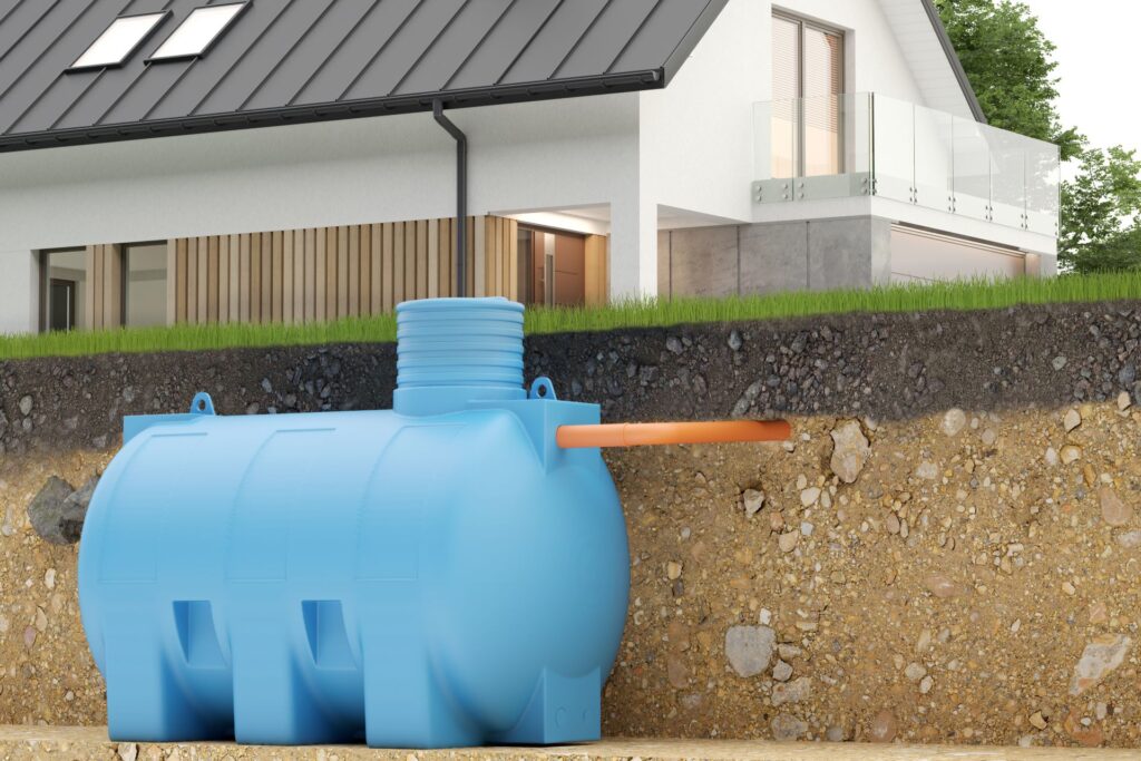 querschnitt eines erdtanks fuer regenwasser neben modernem haus