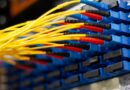 Gelbe LWL Verlegekabel verbunden mit blauen Ports in einer Glasfaser-Verteilerbox