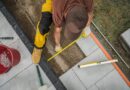 Handwerker verlegt Terrassenplatten | Terrassenüberdachung Düsseldorf