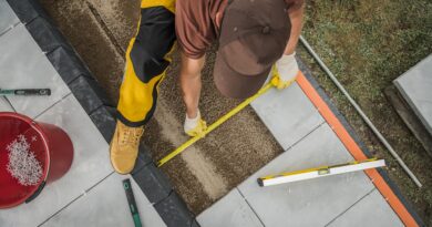 Handwerker verlegt Terrassenplatten | Terrassenüberdachung Düsseldorf